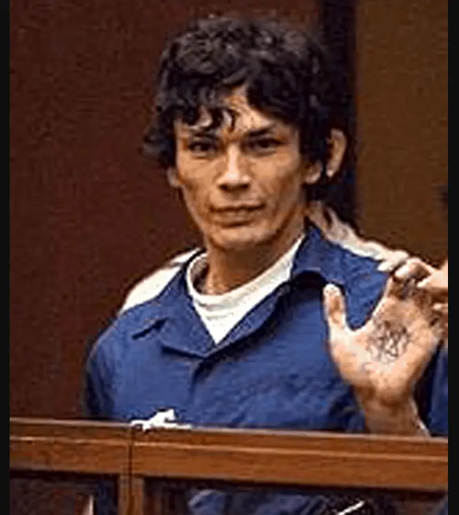 Richard Ramirez isplaying a Satanic sign during his trial