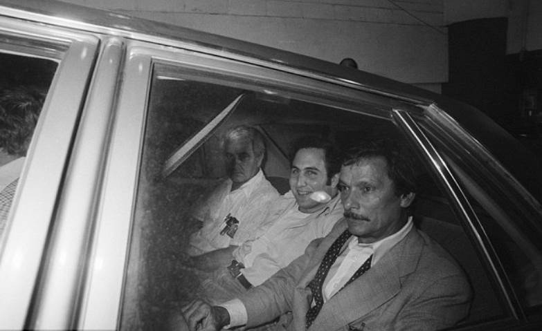 Berkowitz smiling while heading to prison